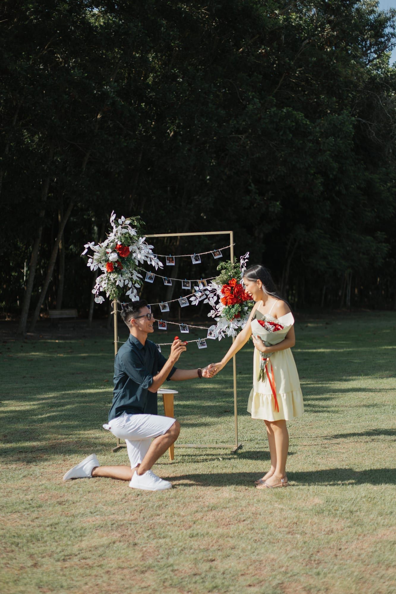 Matheus ajoelhado pedindo Aisha em casamento no jardim